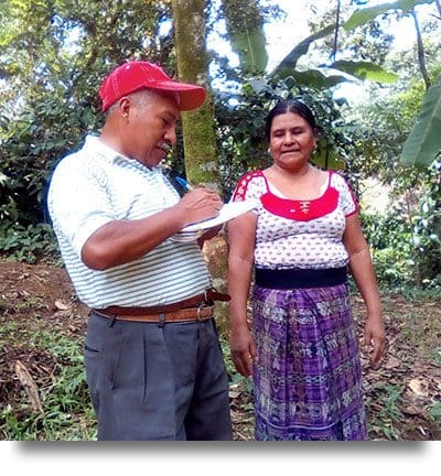 A photo of Julio Lopez, a senior extensionist evaluating a new program participant's yard for placement and design of her new garden.